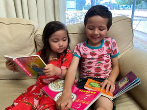 Two young children reading bilingual children's books together